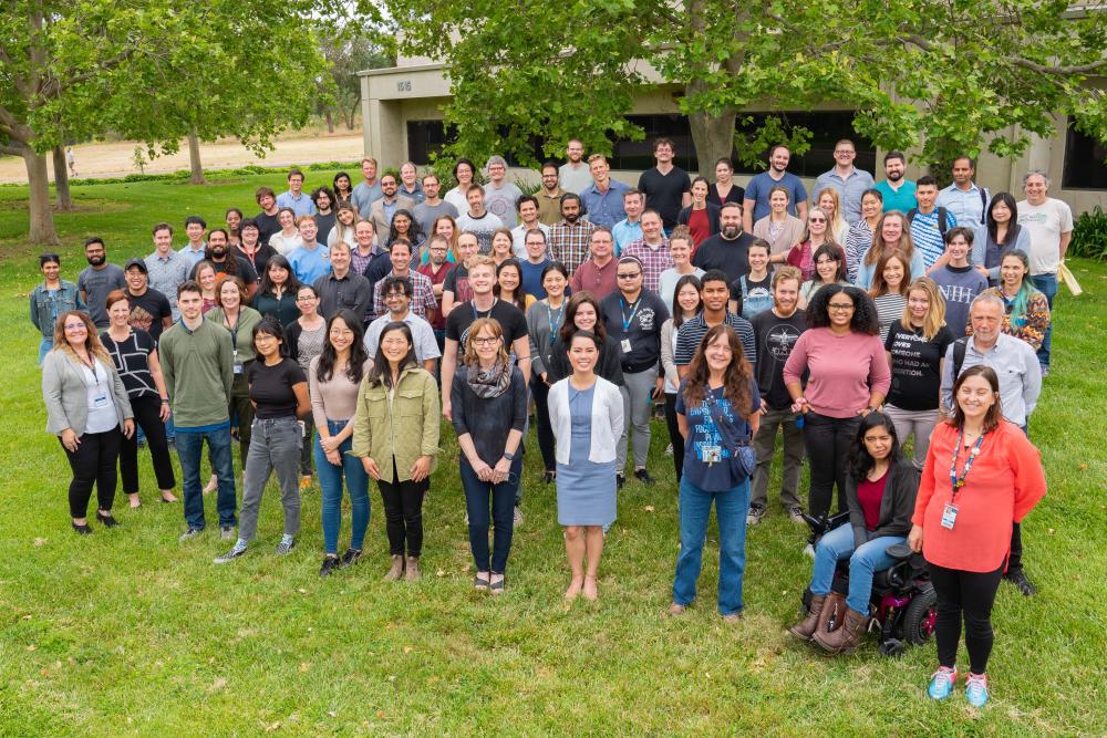A group photo of about 100 CNS faculty, trainees and staff standing on green lawn